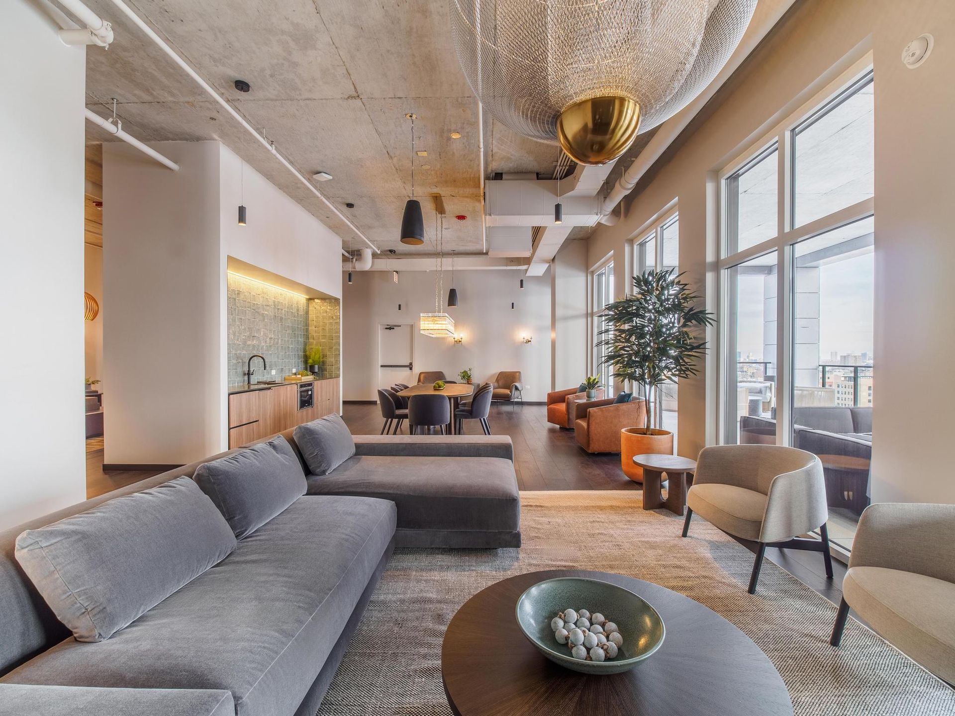 a large velvet sectional across from side chairs along with other seating arrangements in The Thompson at Fulton Market's community lounge