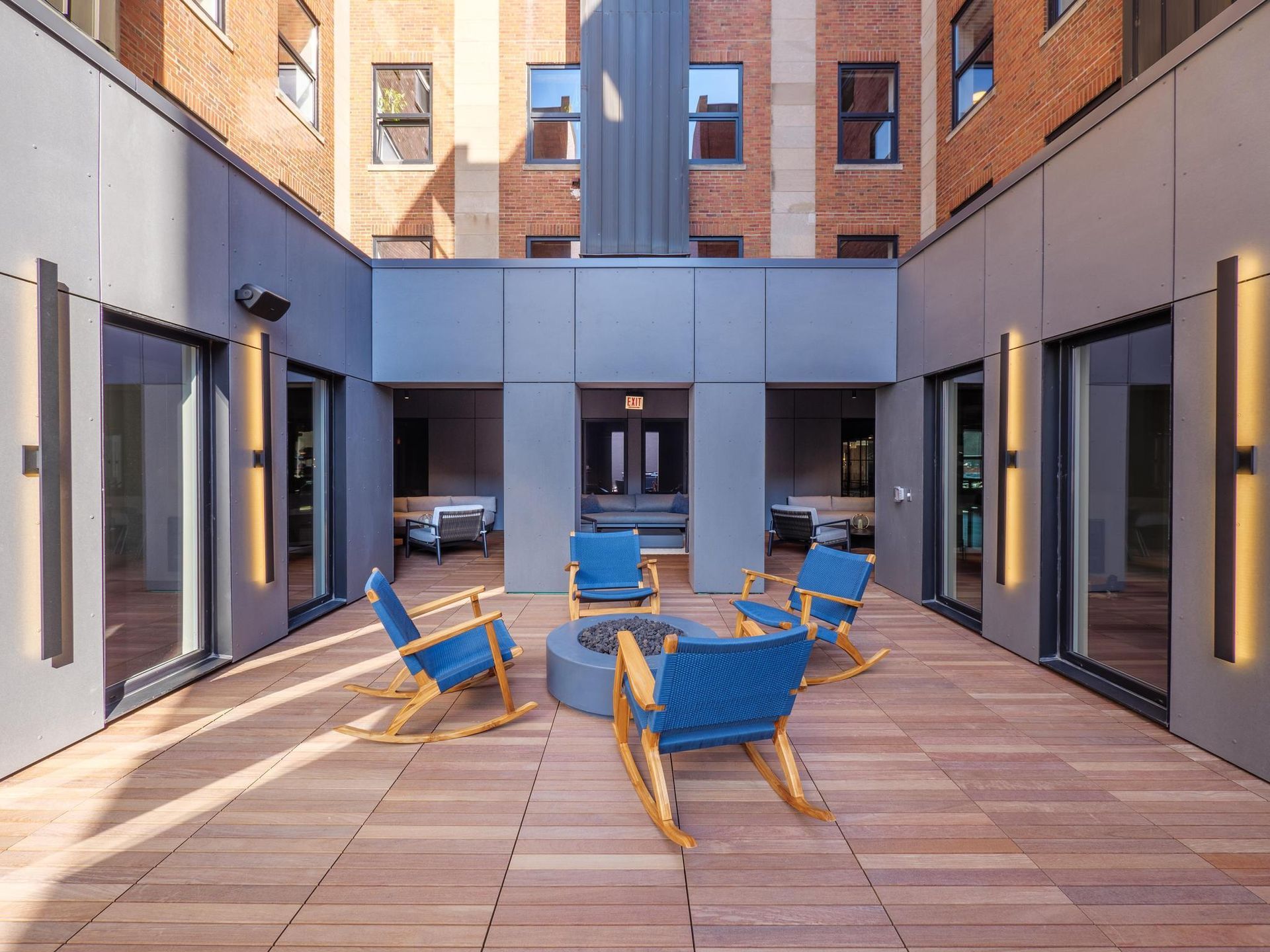The Thompson at Fulton Market's rooftop lounge with blue rocking chairs around a fire pit