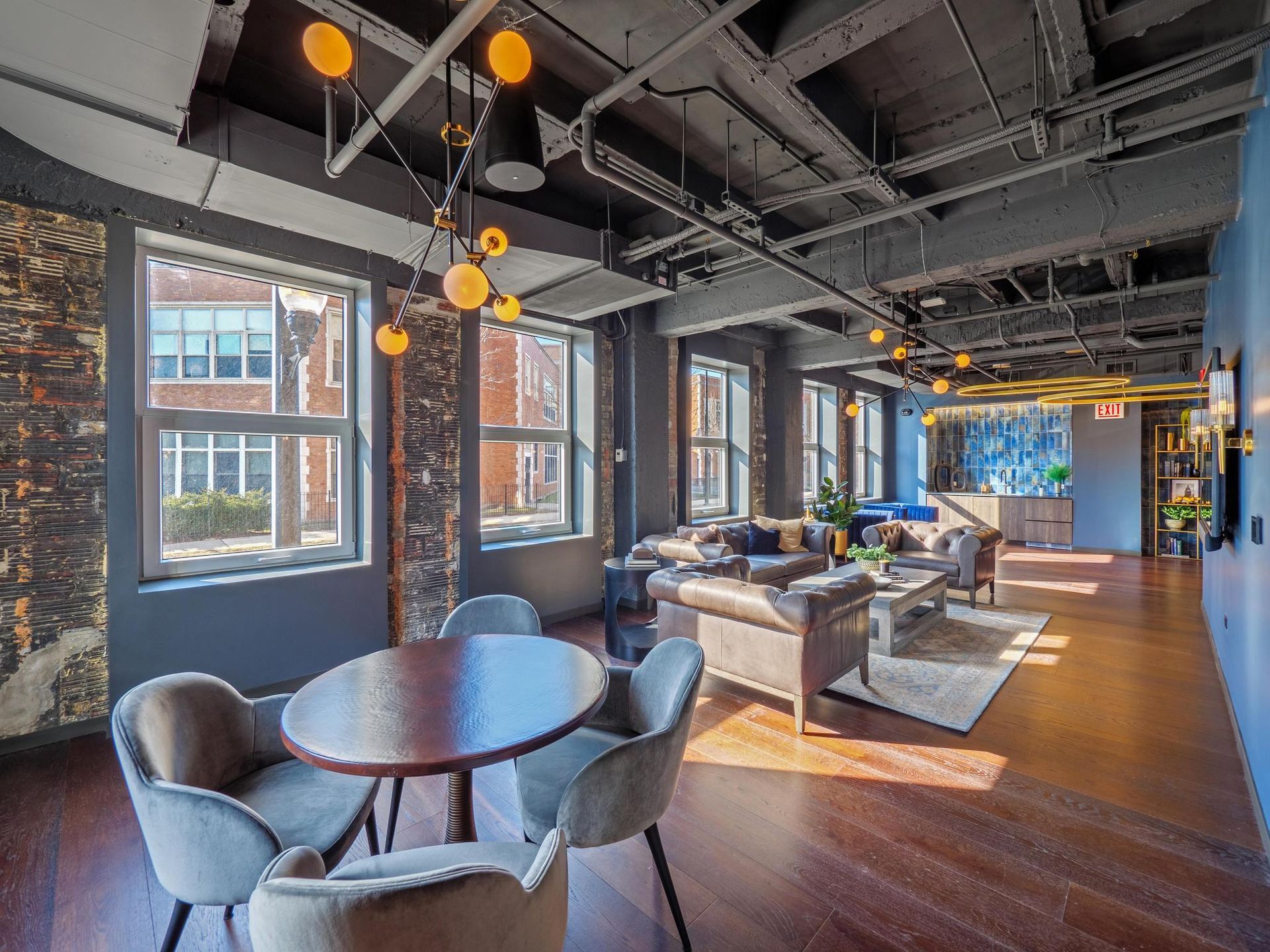 wood table with four chairs by a sitting area in The Thompson at Fulton Market's apartment resident lounge