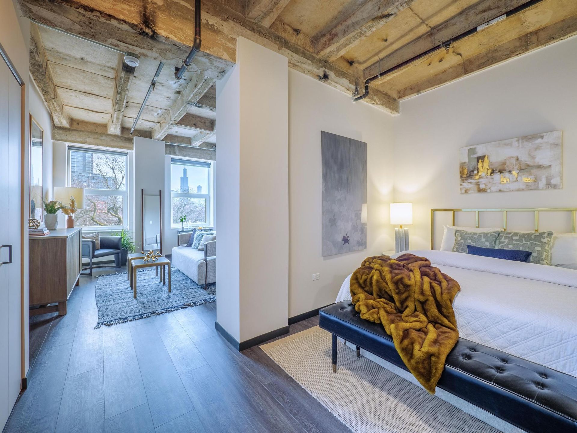 A bedroom with a large bed and a bench