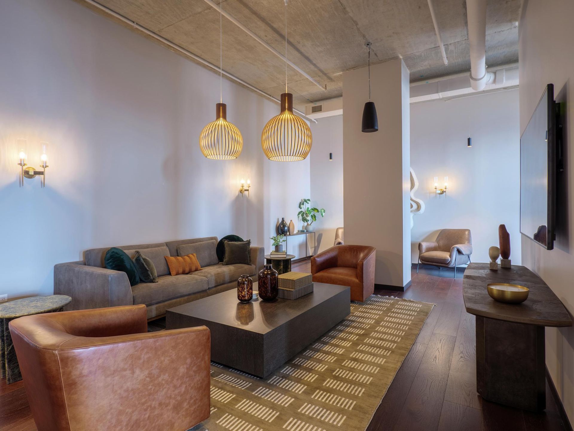 modern lounge area with unique chandeliers in The Thompson at Fulton Market's community room