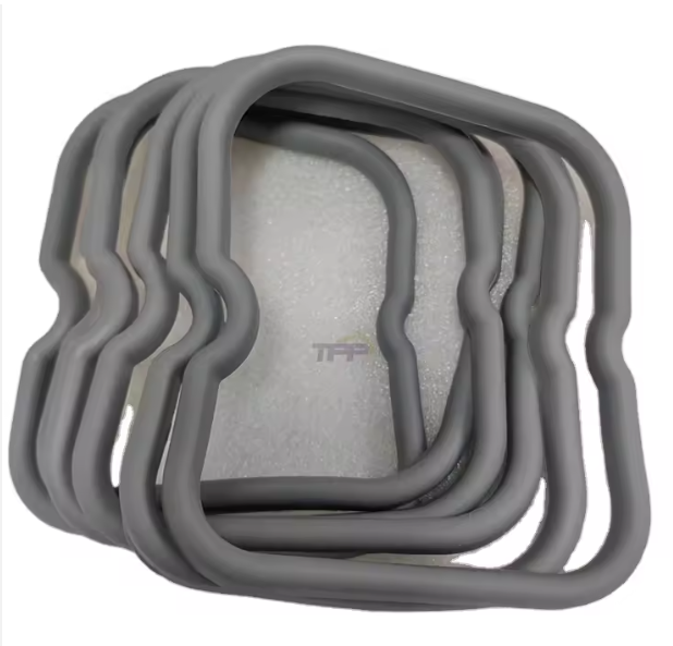 Pila de moldes o marcos cuadrados de silicona gris sobre un fondo claro.