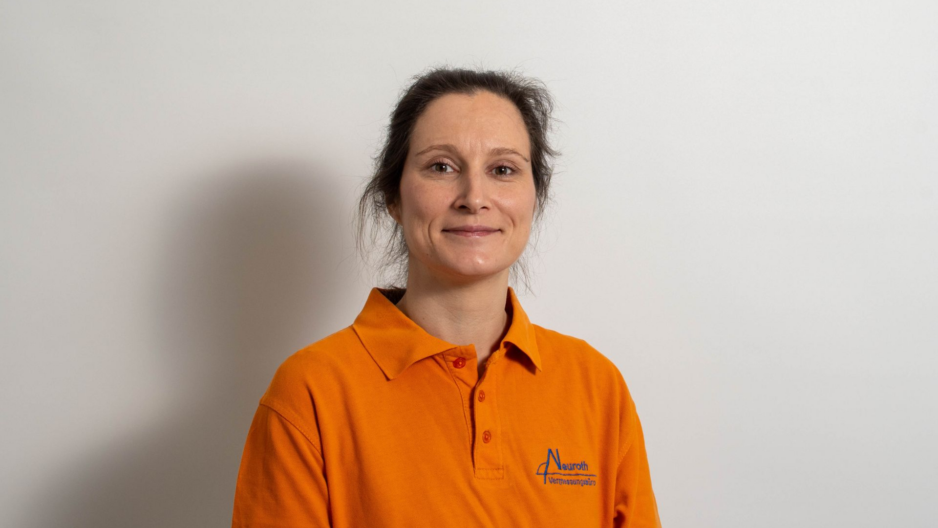Frau mit Dutt, trägt ein Rundhalsshirt, grau-weiße Grafik.
