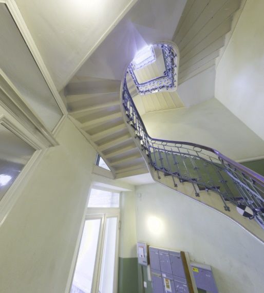 Eine Wendeltreppe in einem Gebäude mit lila Schließfächern