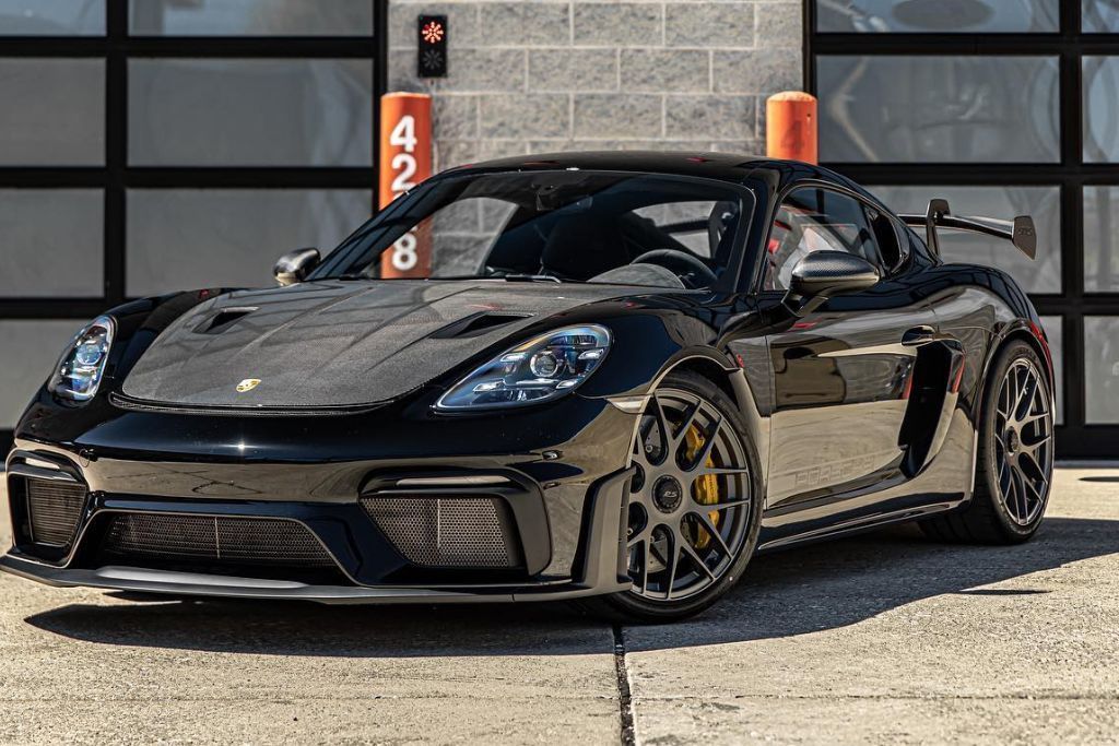 A sleek black sports car parked outdoors with a glossy finish, showcasing the smooth appearance of a freshly applied paint protection film (PPF).