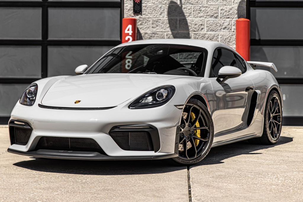 A sleek white sports car parked outdoors, showcasing a pristine, glossy finish achieved through a combination of paint protection film (PPF) and ceramic coating. The smooth, reflective surface emphasizes the enhanced aesthetics and showroom-quality appearance.