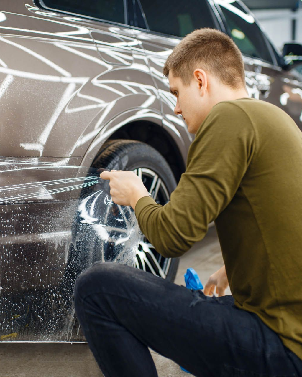 A person is washing a car wheel with foam
