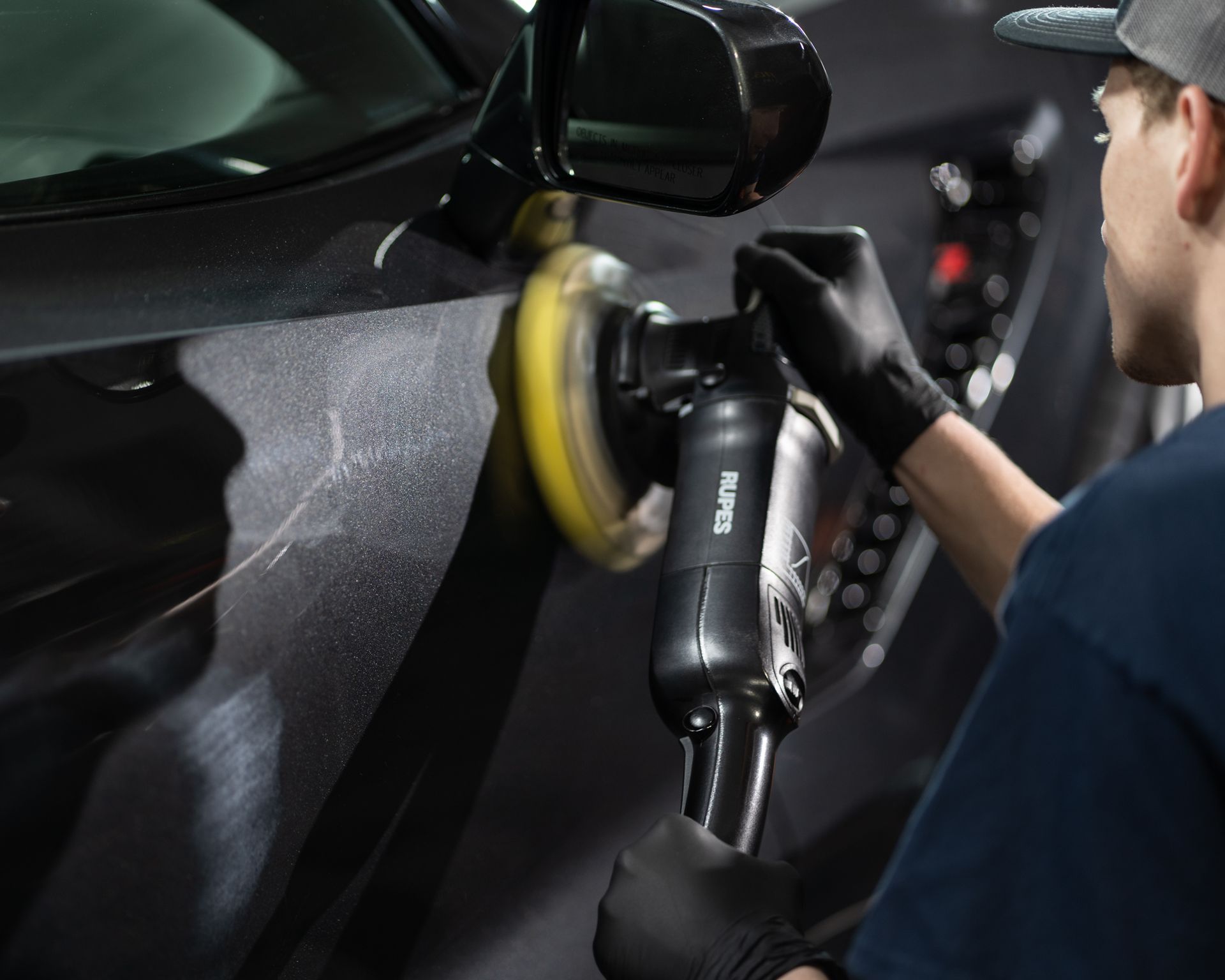 A car is being washed with foam in a garage.