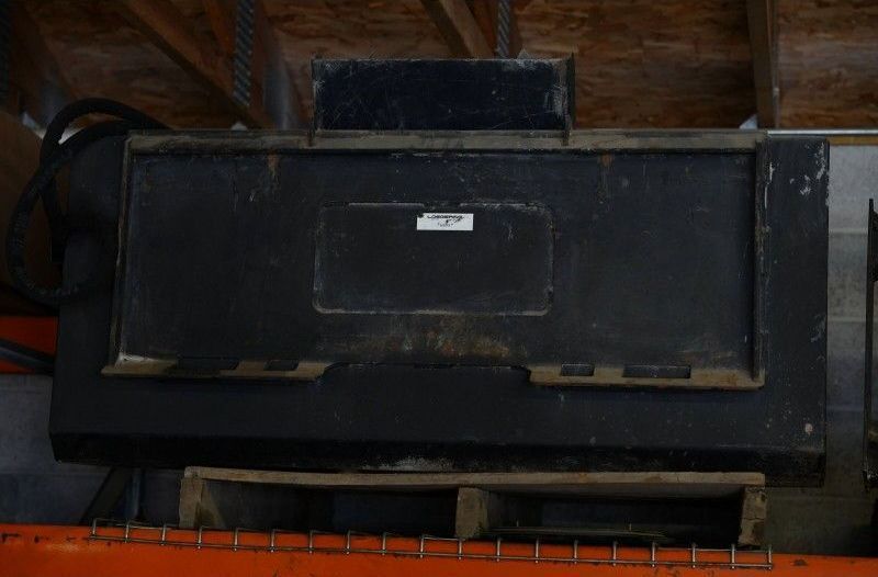 Large black industrial machine on a factory floor with a small central label