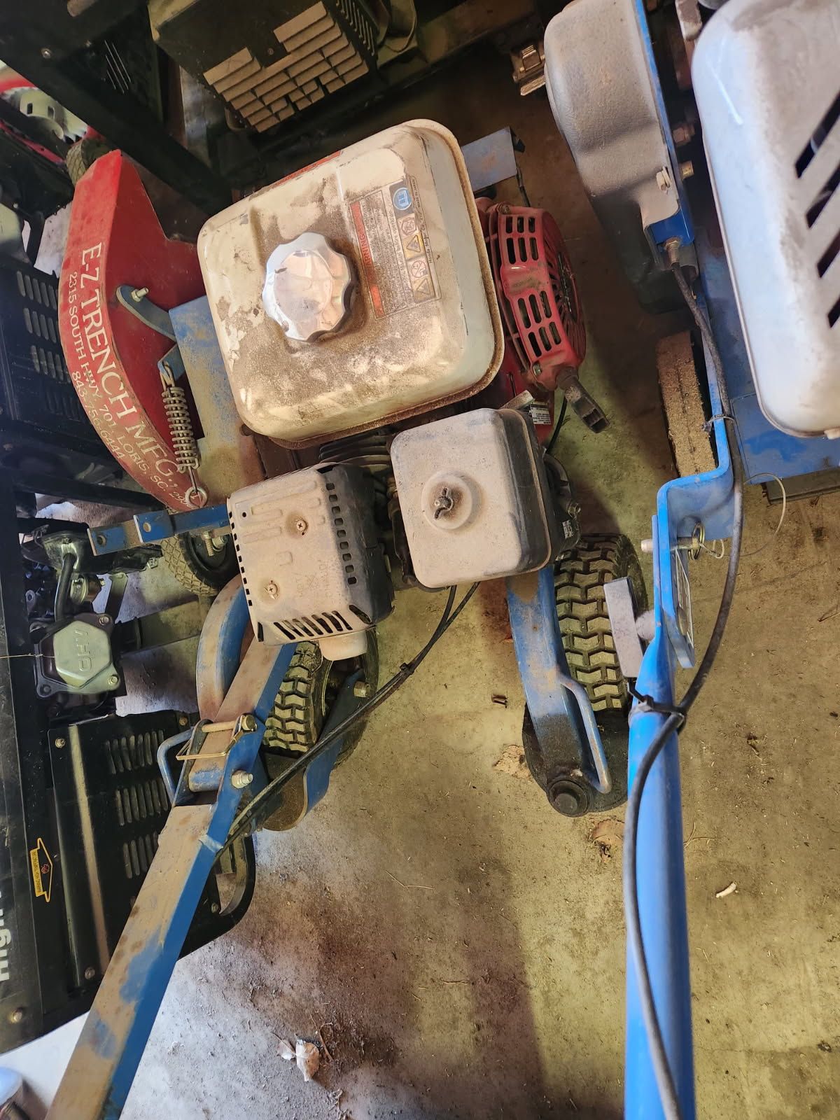 Cluttered mechanical equipment with red, white, and blue components in a workshop-like setting