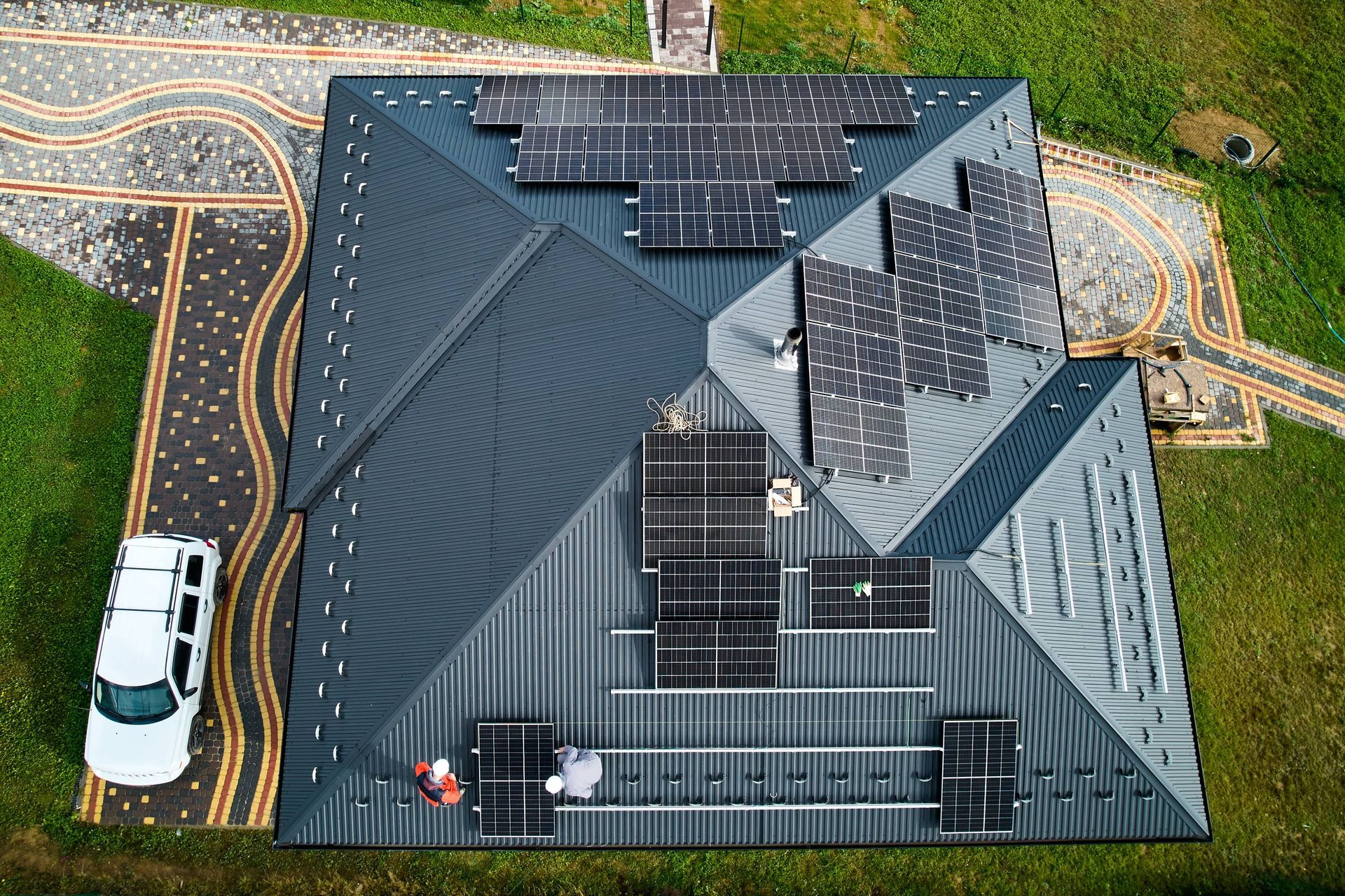 Men workers installing solar panels on roof for EDM Home Services