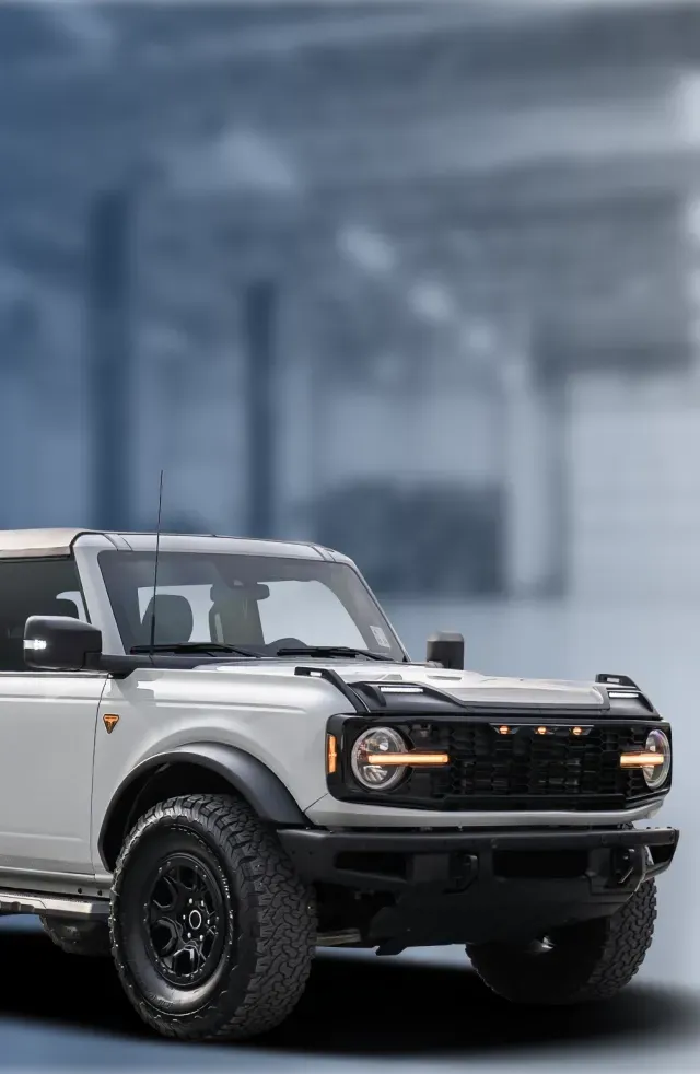 Garage with light blue background, white Bronco parked | Hometown Tire & Service