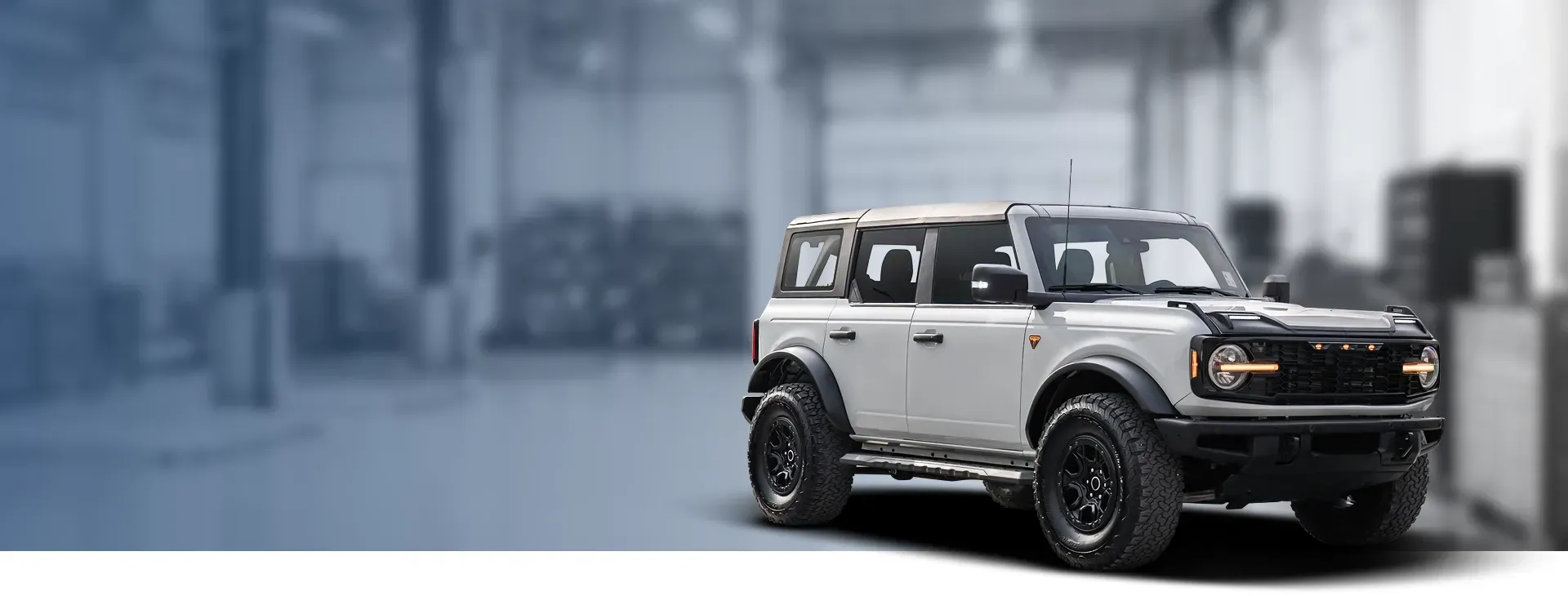 Garage with light blue background, white Bronco parked | Hometown Tire & Service