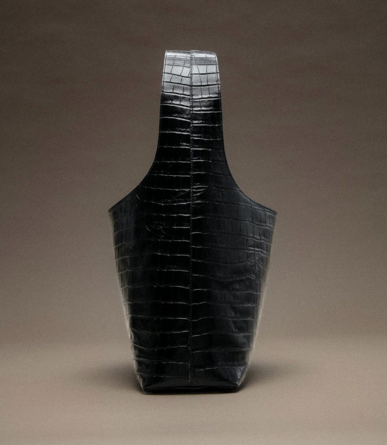 Black, textured tote bag with a tall, rectangular handle.