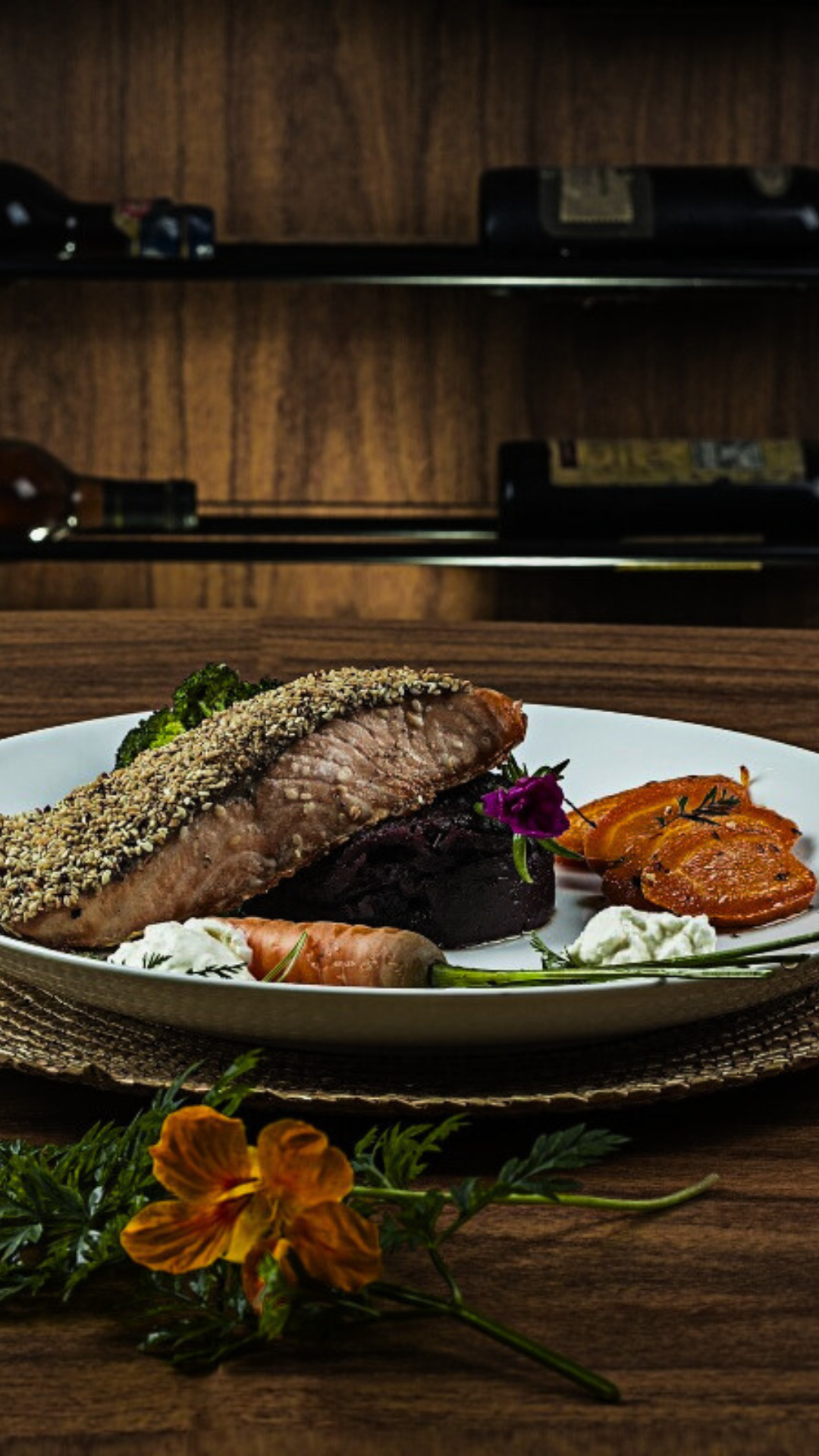 Um prato de comida com carne e legumes em uma mesa de madeira.