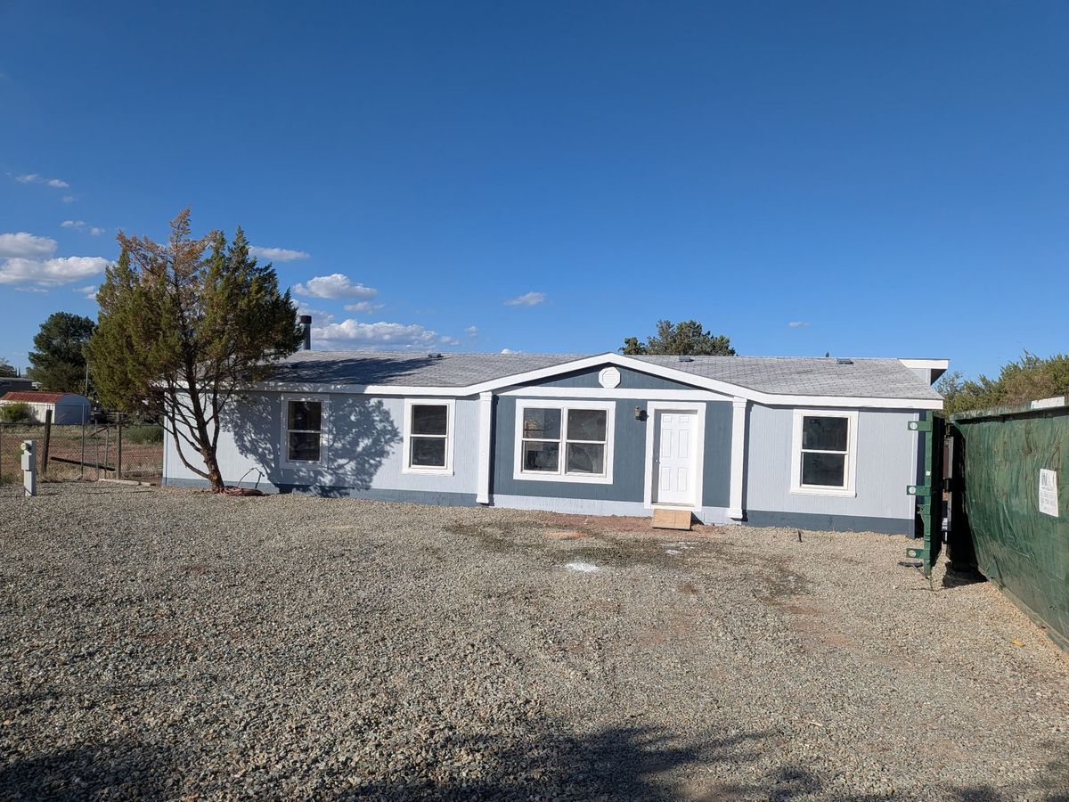 Renovated blue manufactured home with fresh gravel lot