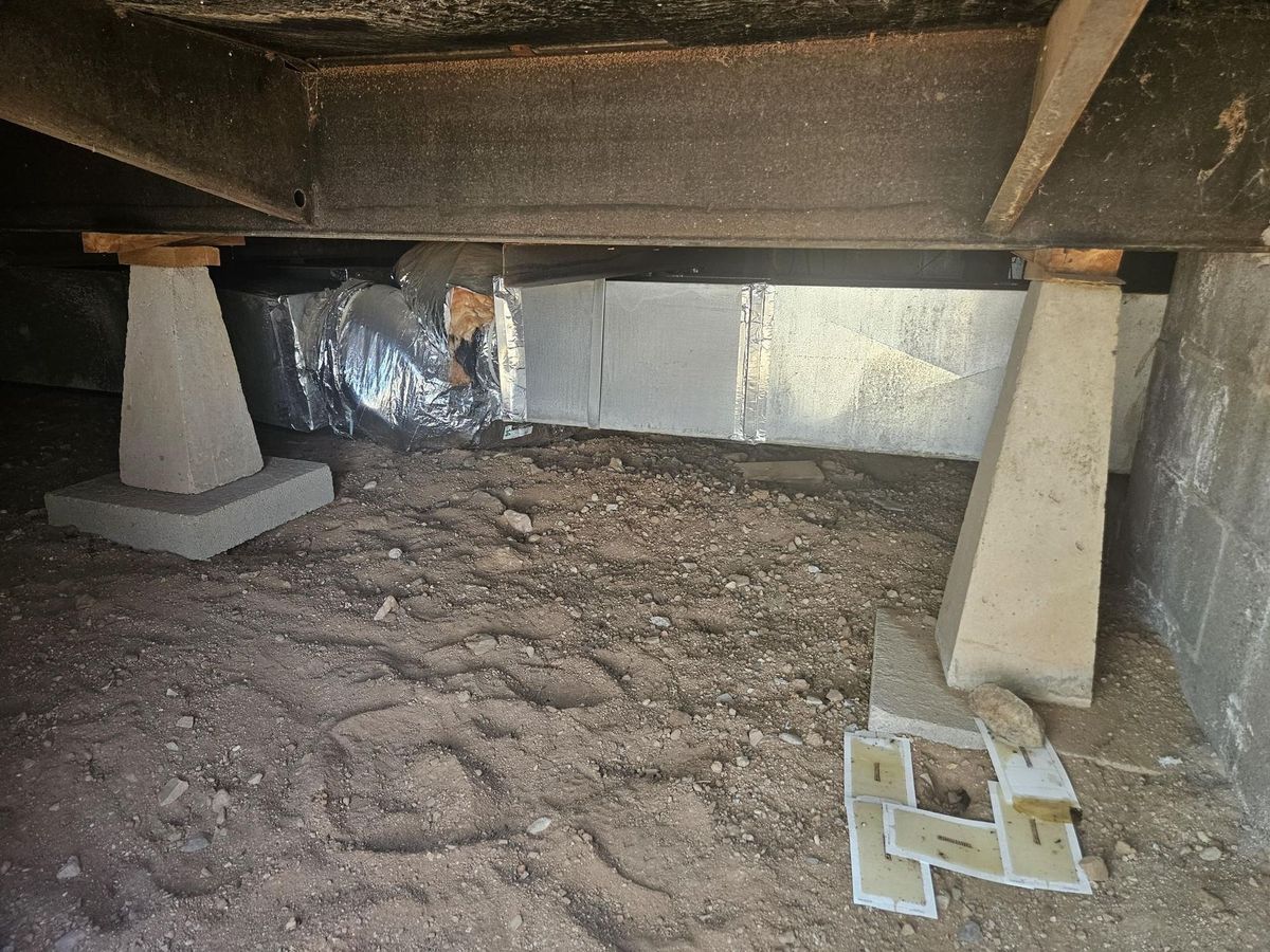 Crawlspace showing piers and ductwork under a manufactured home