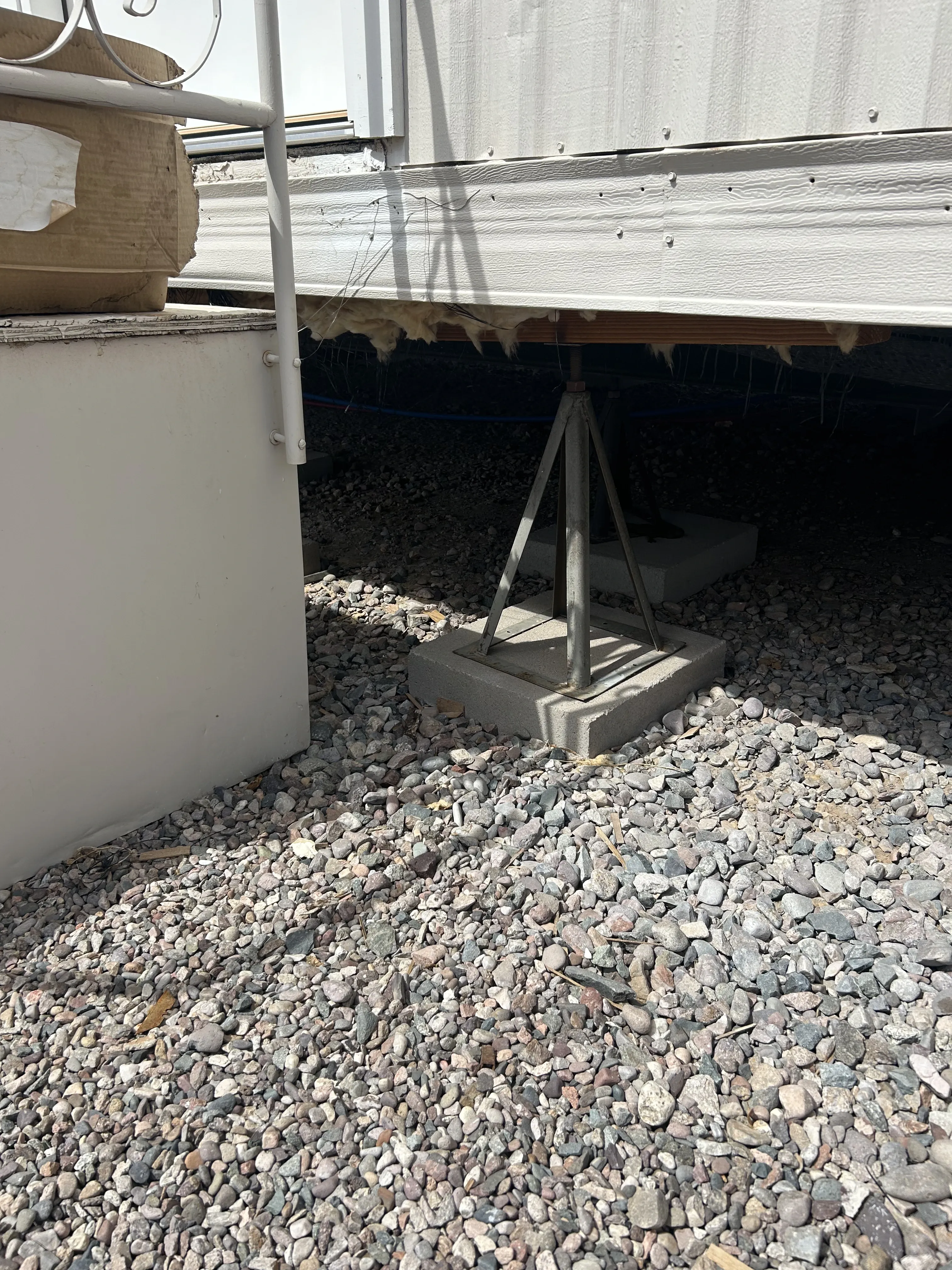 Steel pier stand on a concrete pad under a manufactured home