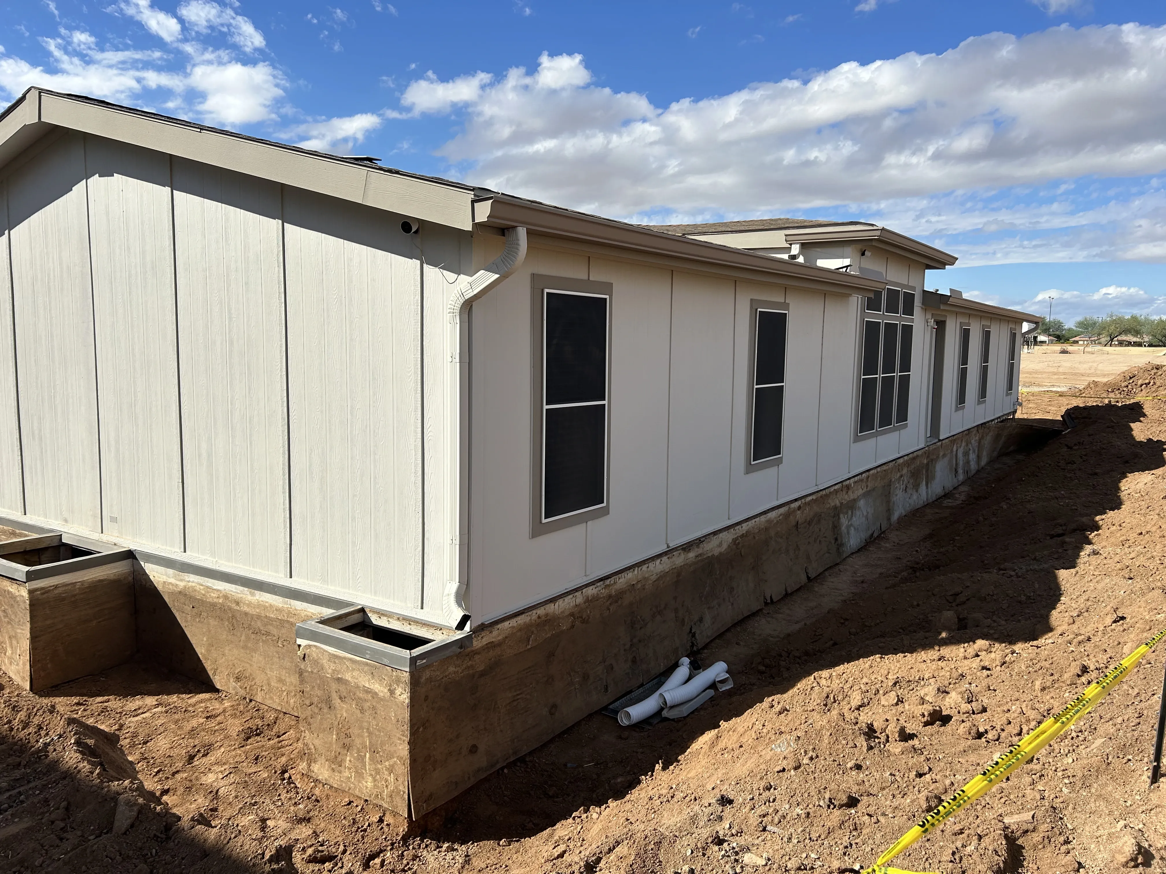 Corner of a manufactured home on a new block foundation with drainage