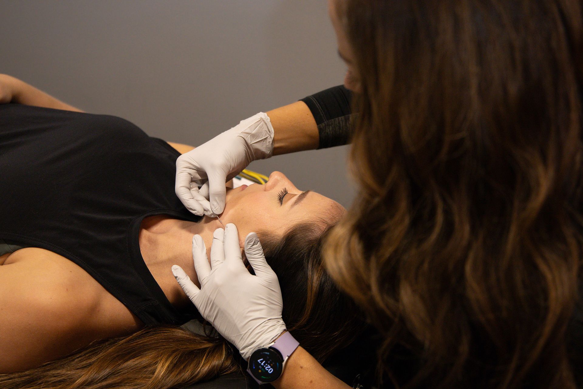 Dentist examining a patient's mouth with gloved hands during a dental procedure