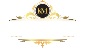 Gold ornamental logo with black circle monogram “KM” centered between decorative flourishes.