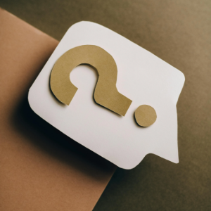 White speech bubble with a tan question mark on a brown background
