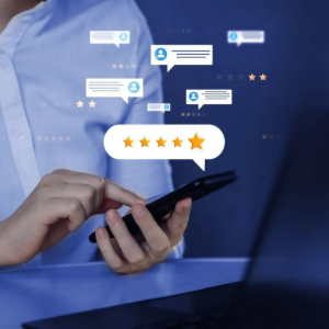 Person holding a smartphone with floating chat and 5-star review icons above a blue desk