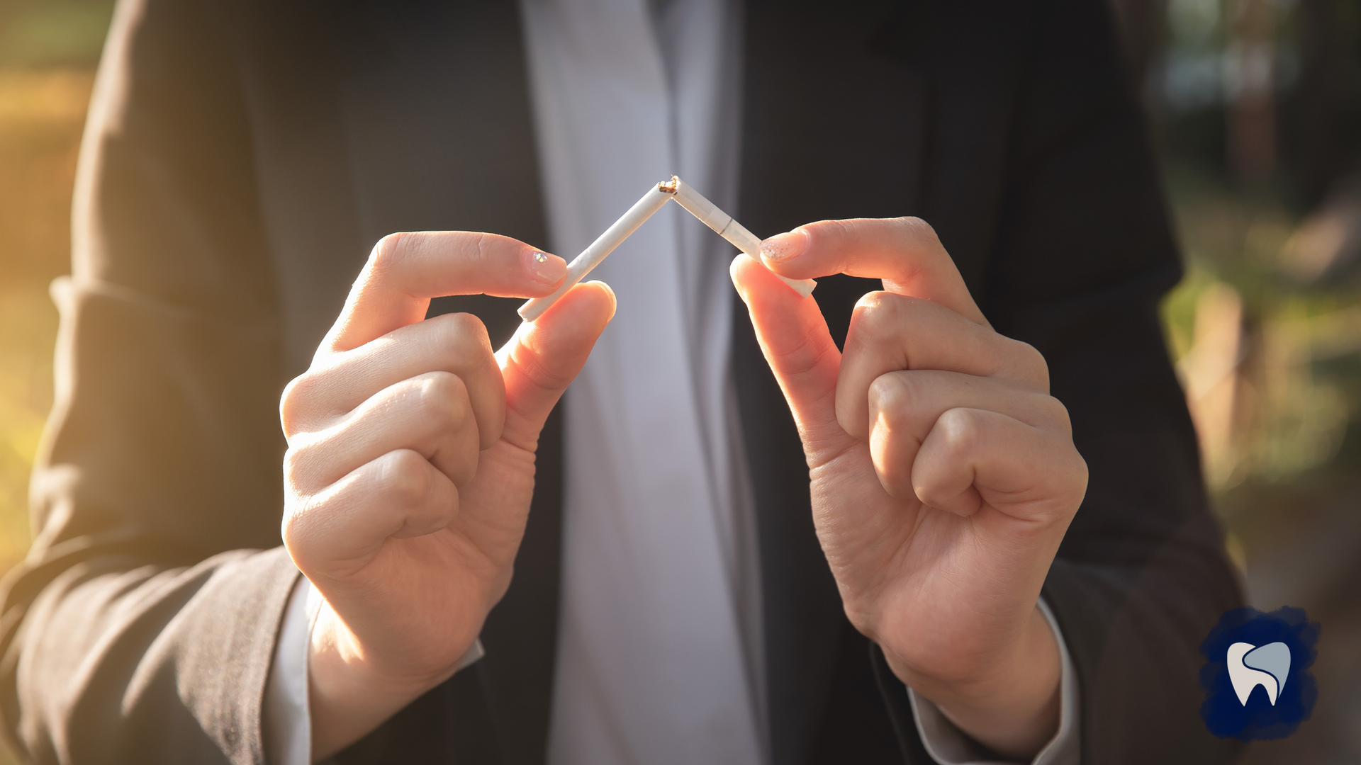 Person holding a broken cigarette, symbolizing quitting smoking.