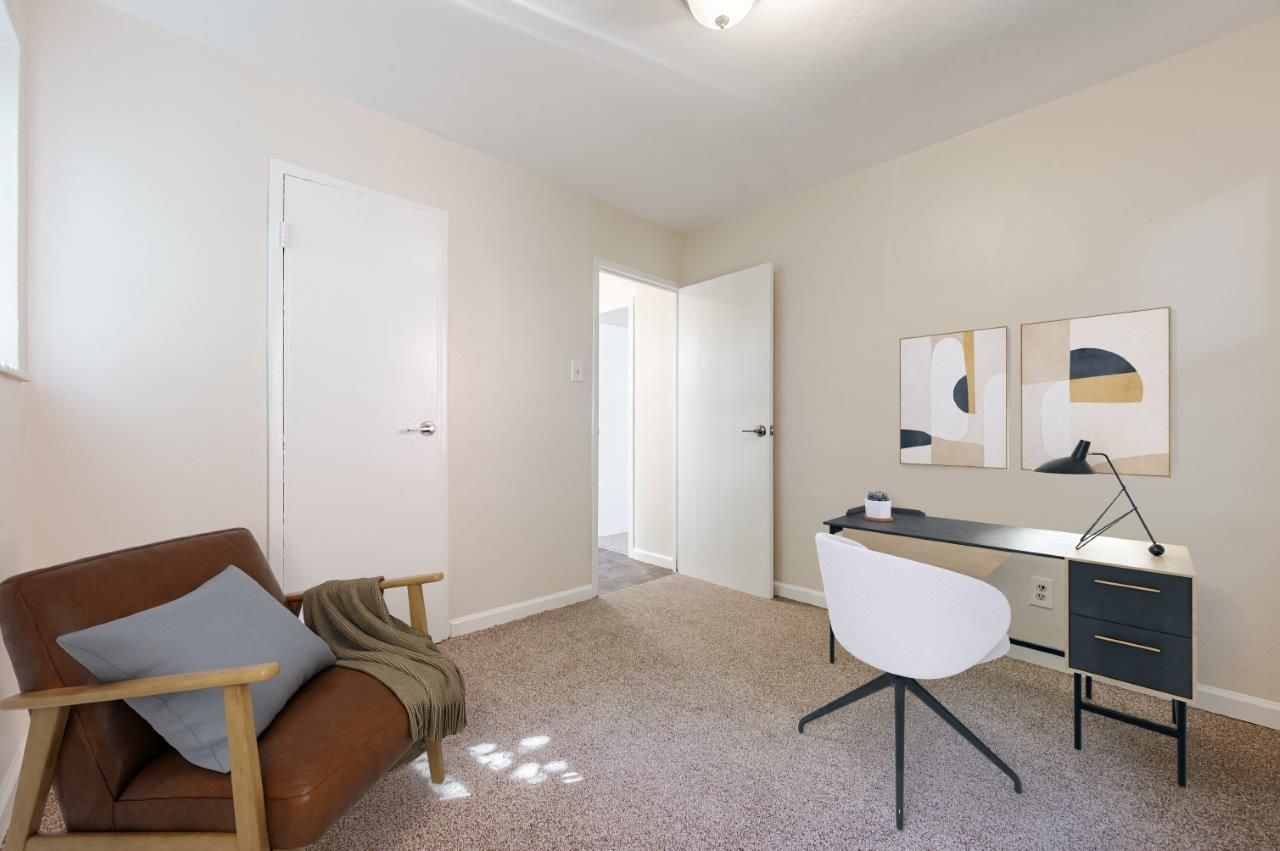 Bedroom staged as an office with beige carpet.