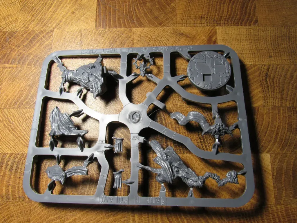 Gray plastic sprue containing miniature model parts for assembly.