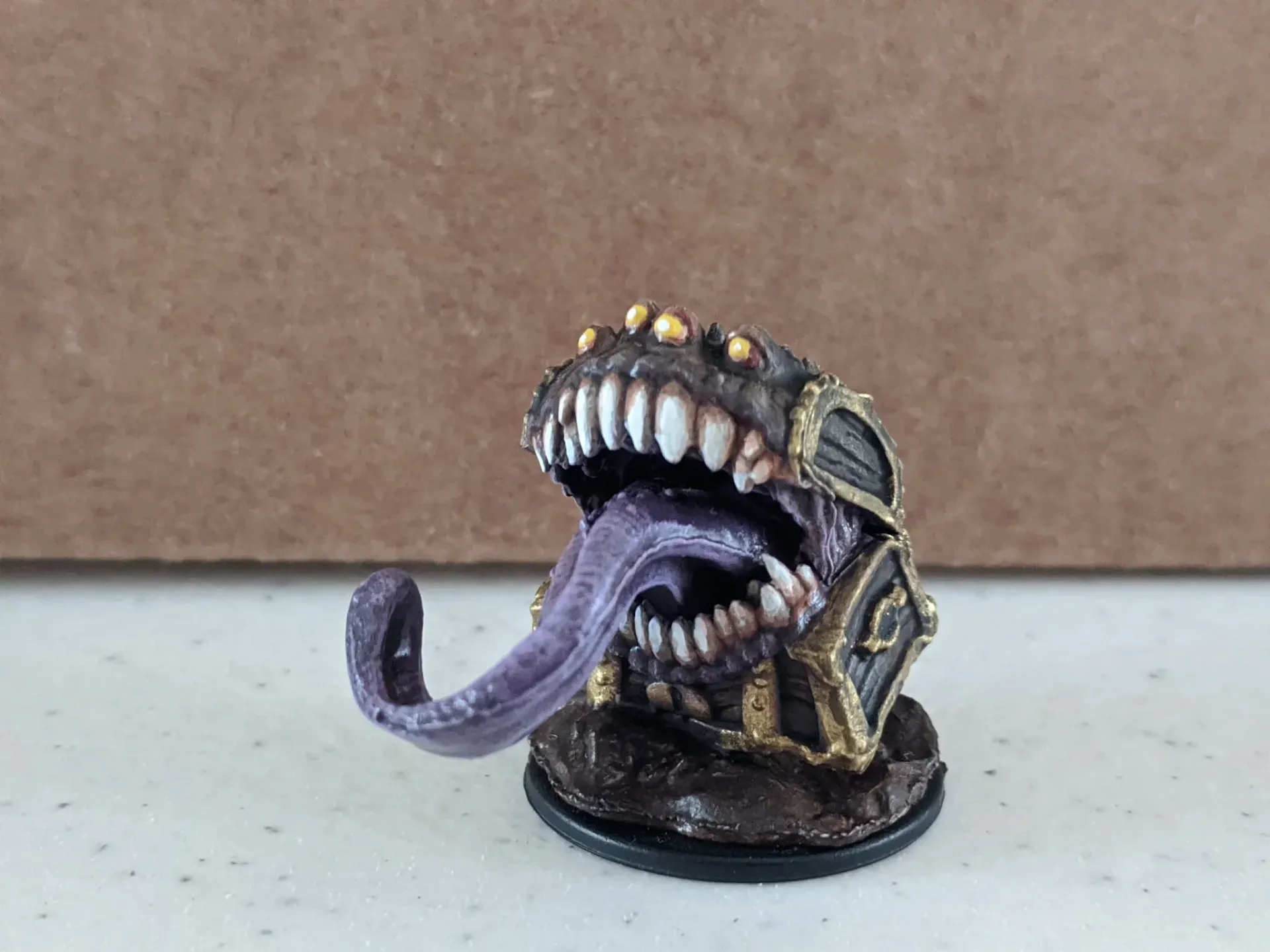 Miniature Mimic monster with large teeth and purple tongue.