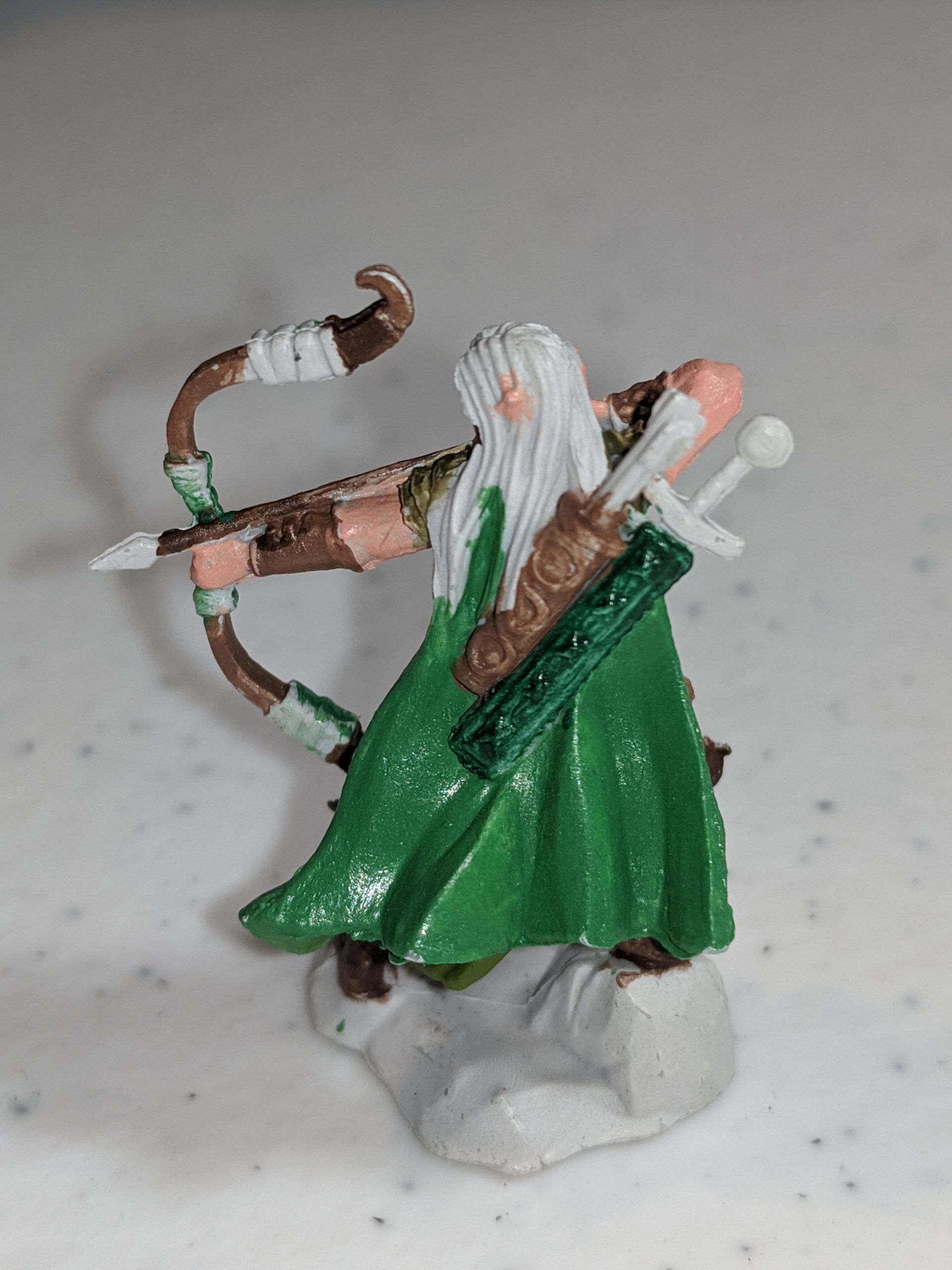 Miniature figure of an archer with a white beard, green robe, and bow drawn.