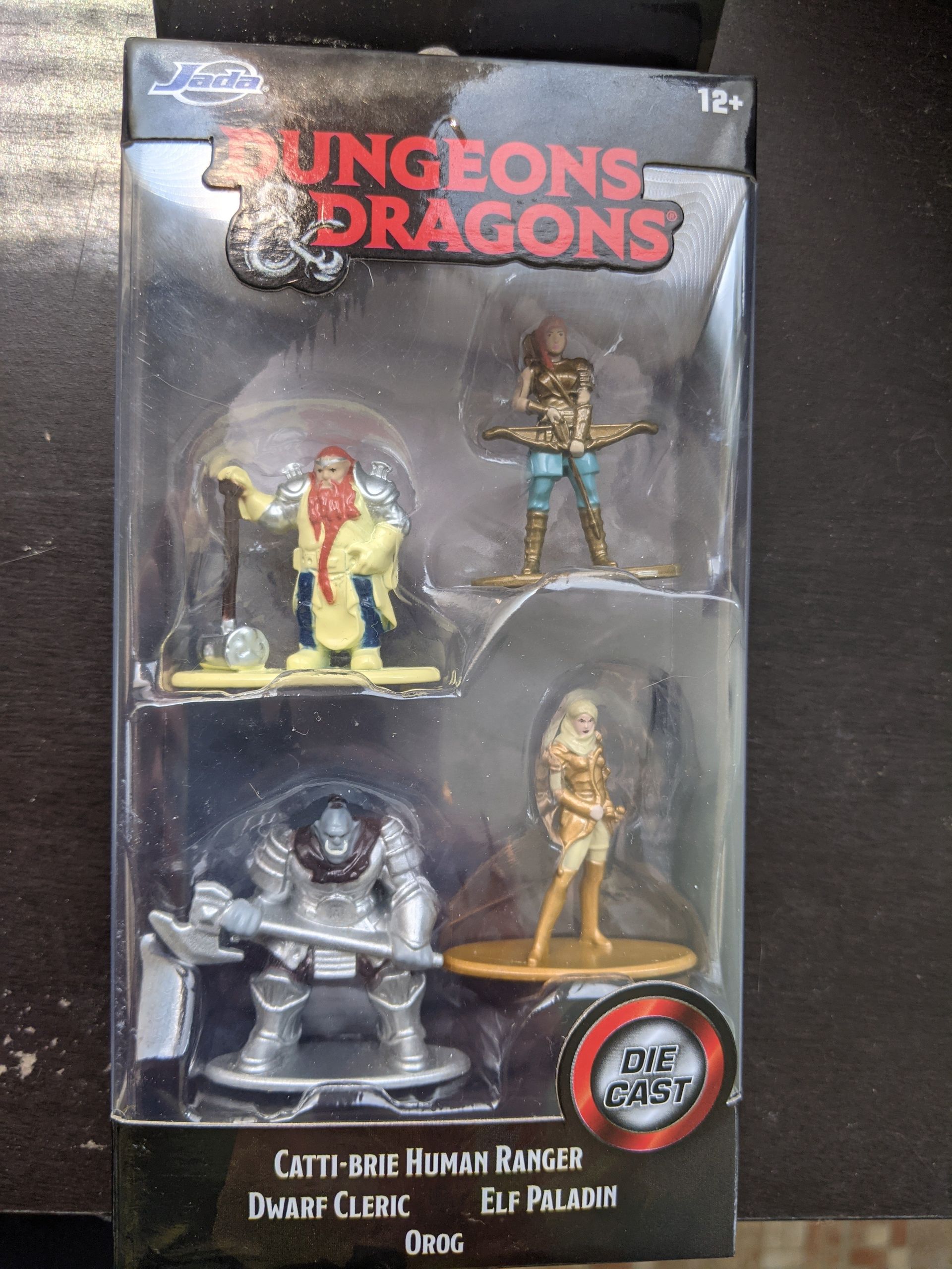 Dungeons & Dragons miniatures in packaging: Human Ranger, Dwarf Cleric, Elf Paladin, and Orc.