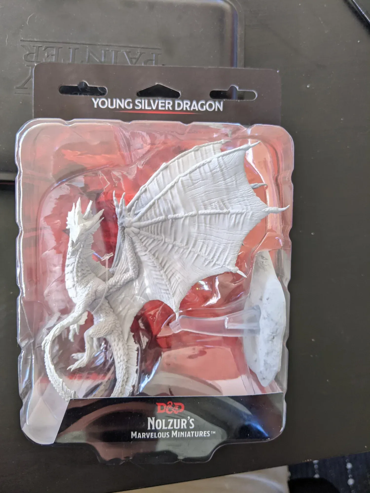 Young silver dragon miniature in packaging.