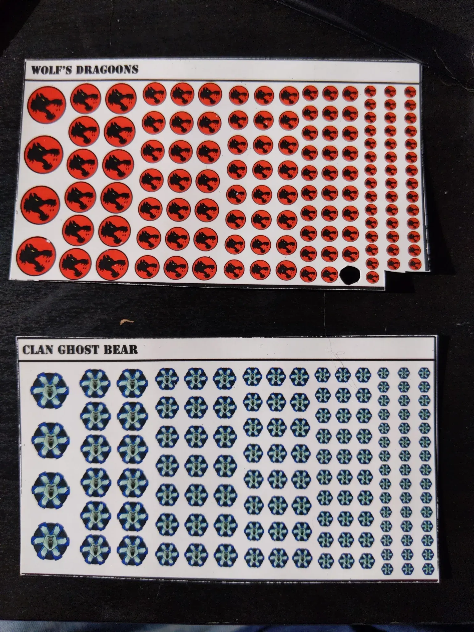 Two sheets of stickers: red dragon symbols and blue cross symbols.