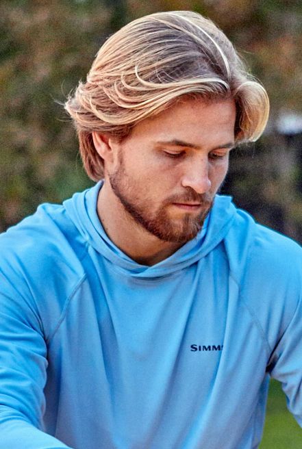 A man with a beard is wearing a blue hoodie.