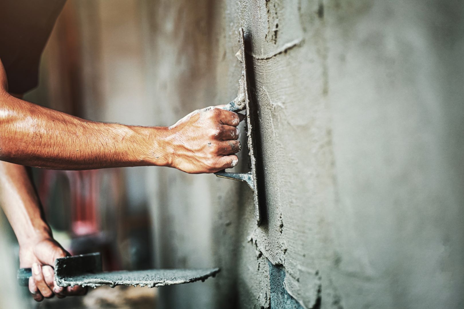 A Man Is Plastering A Wall With A Trowel