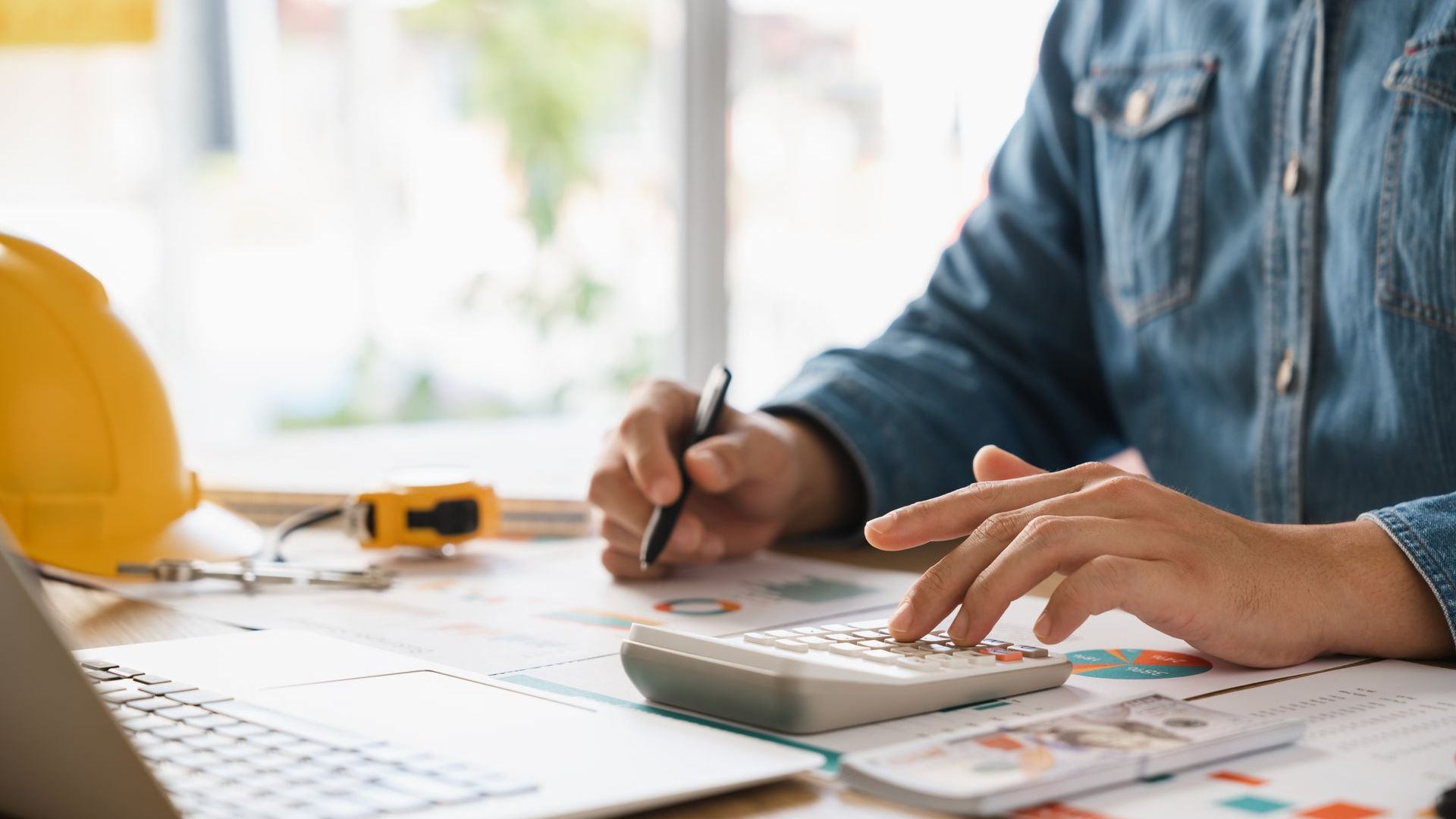Two Construction Workers Are Standing In Front Of A House Under Construction