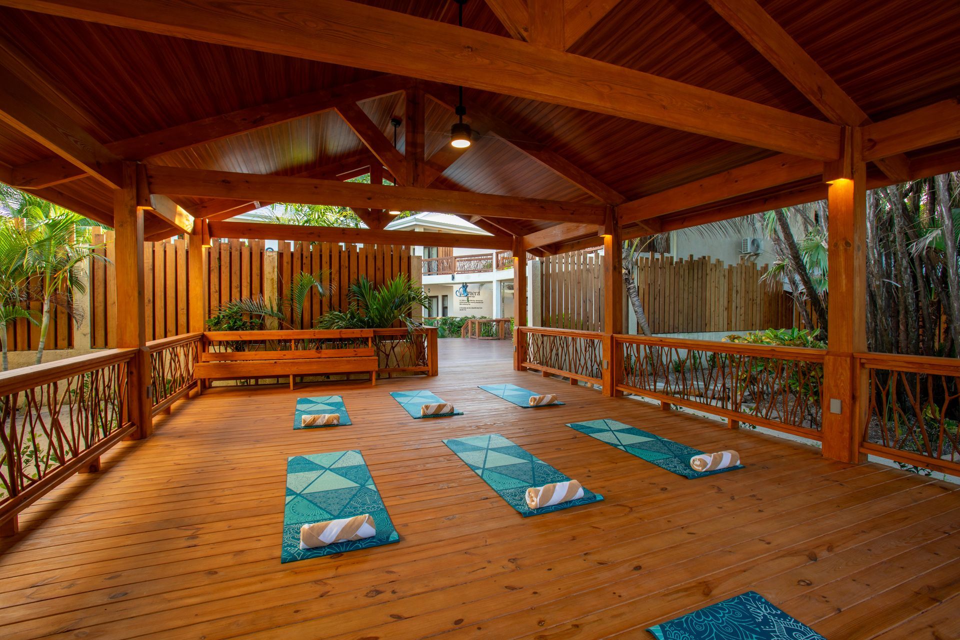 Wooden outdoor yoga pavilion with mats laid out on the floor and benches around the edges