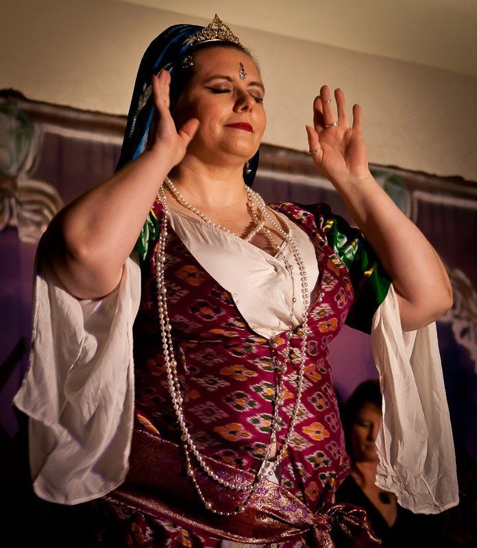 A woman in a purple and green dress is dancing