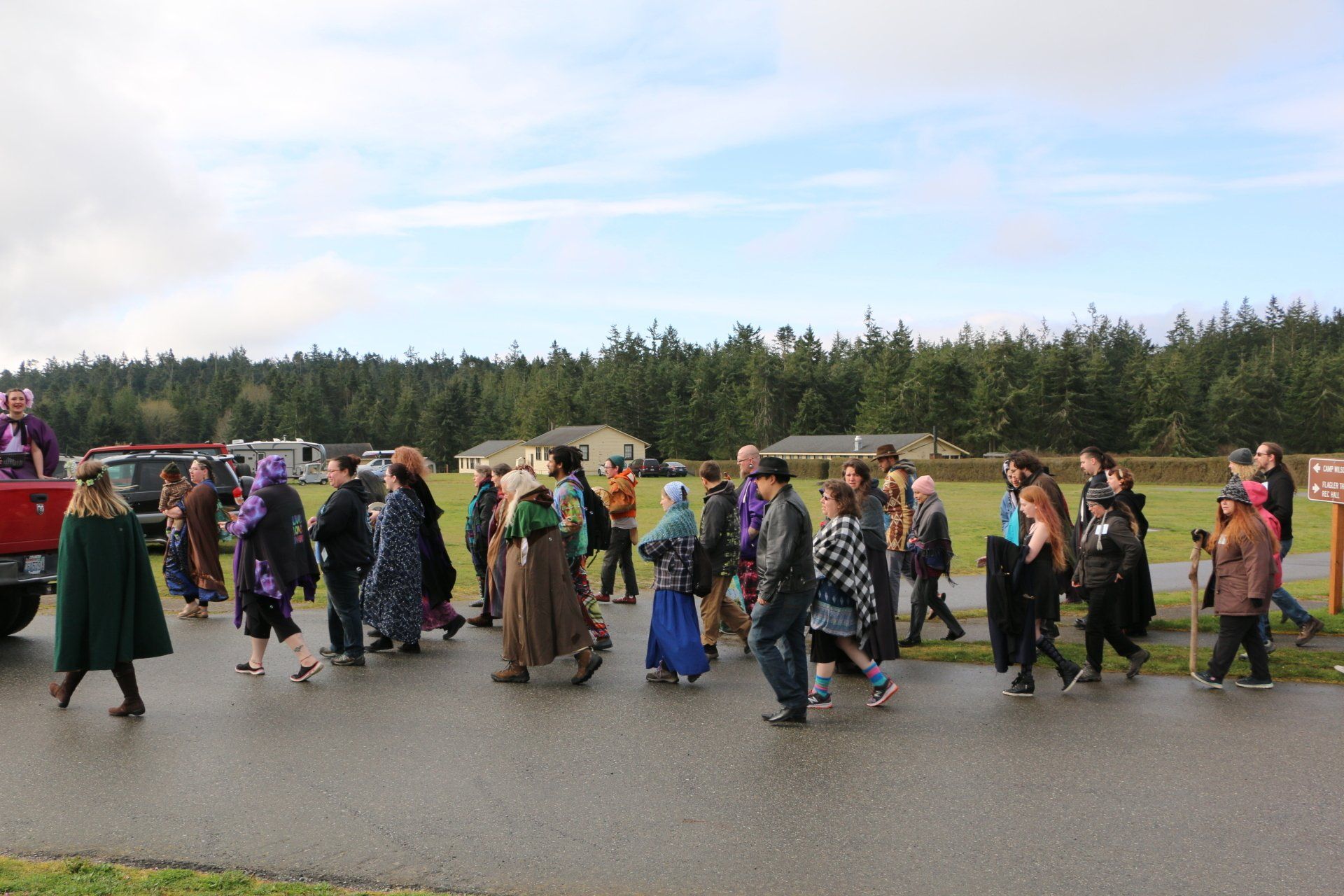 A large group of people are walking down a street.