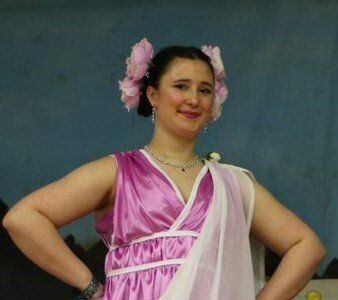 A woman in a pink dress with flowers in her hair