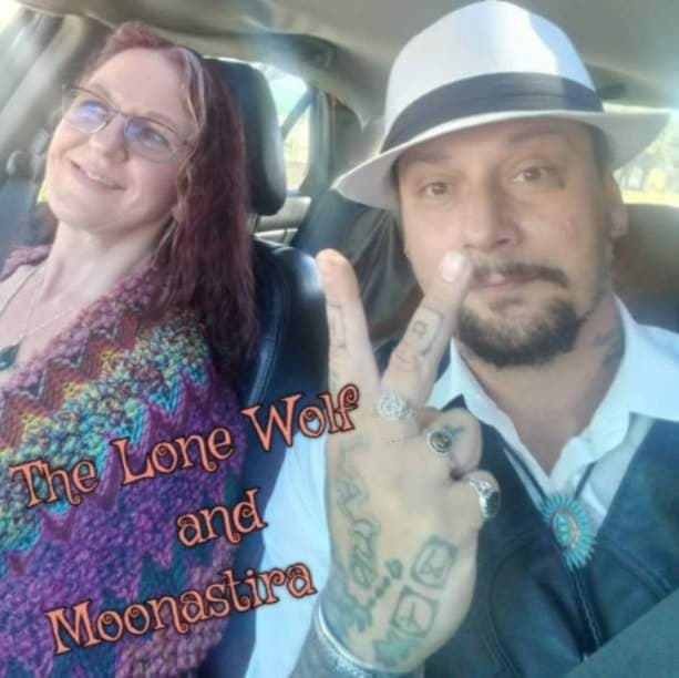 A man and a woman are in a car and the man is wearing a hat