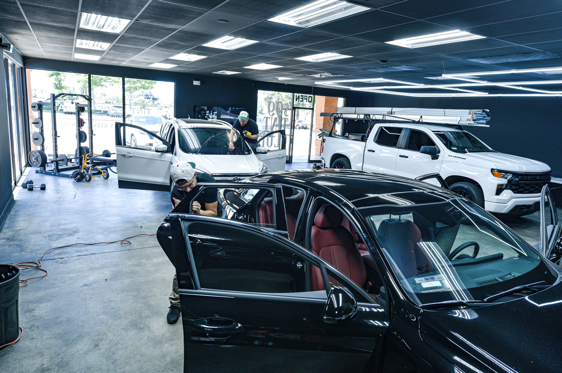 Two men tinting car windows at $99 Tint Club in Yucaipa, CA Window tinting shop.