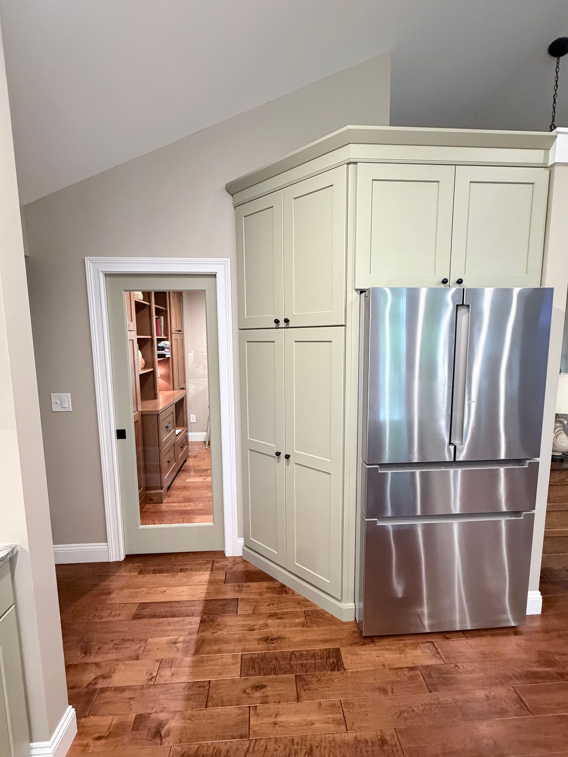 Two-person Wood and Stone team installing upper cabinets in a Northern Kentucky kitchen