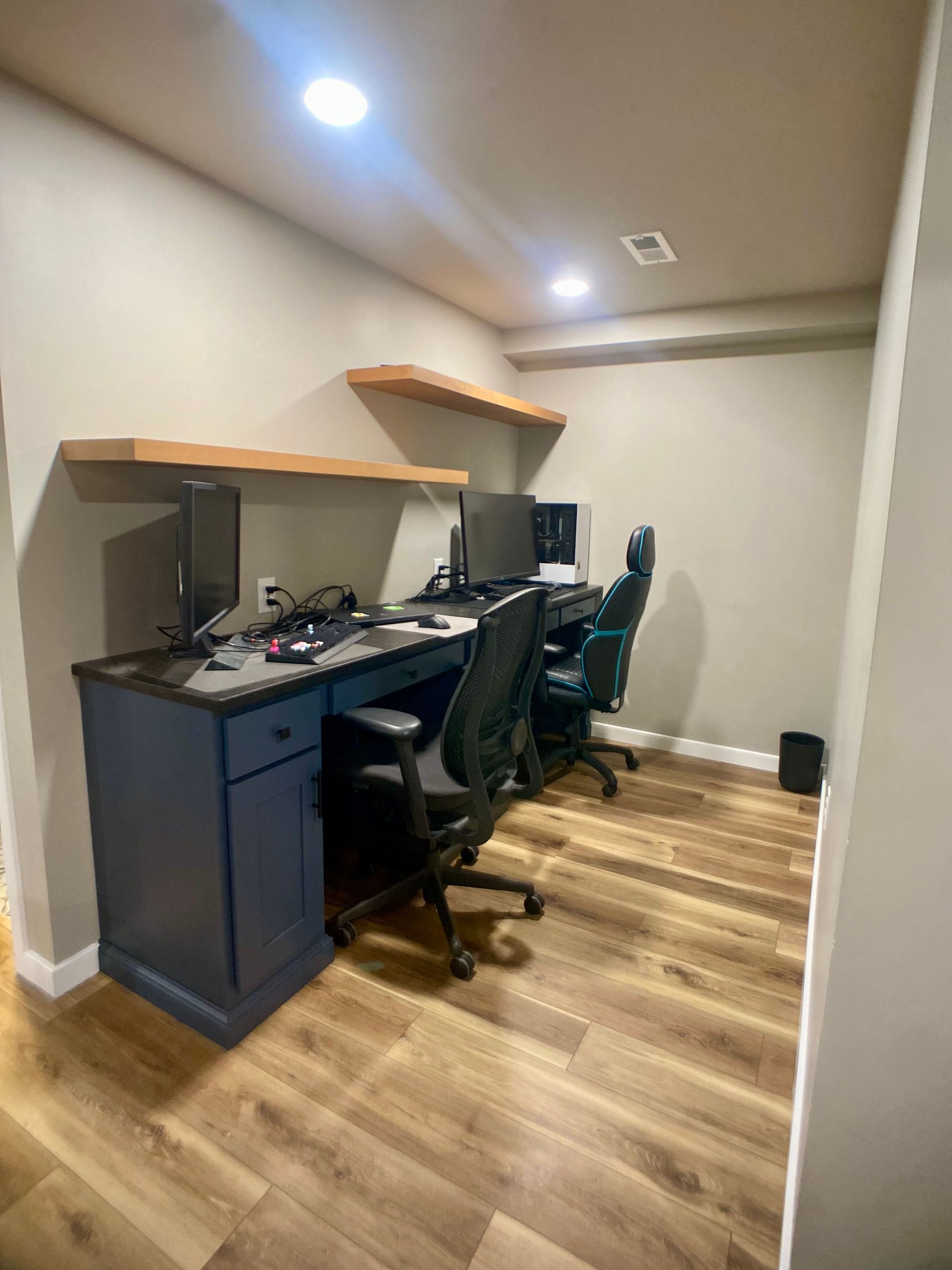 Finished basement interior with custom built-in cabinetry, shelving, and bar surface
