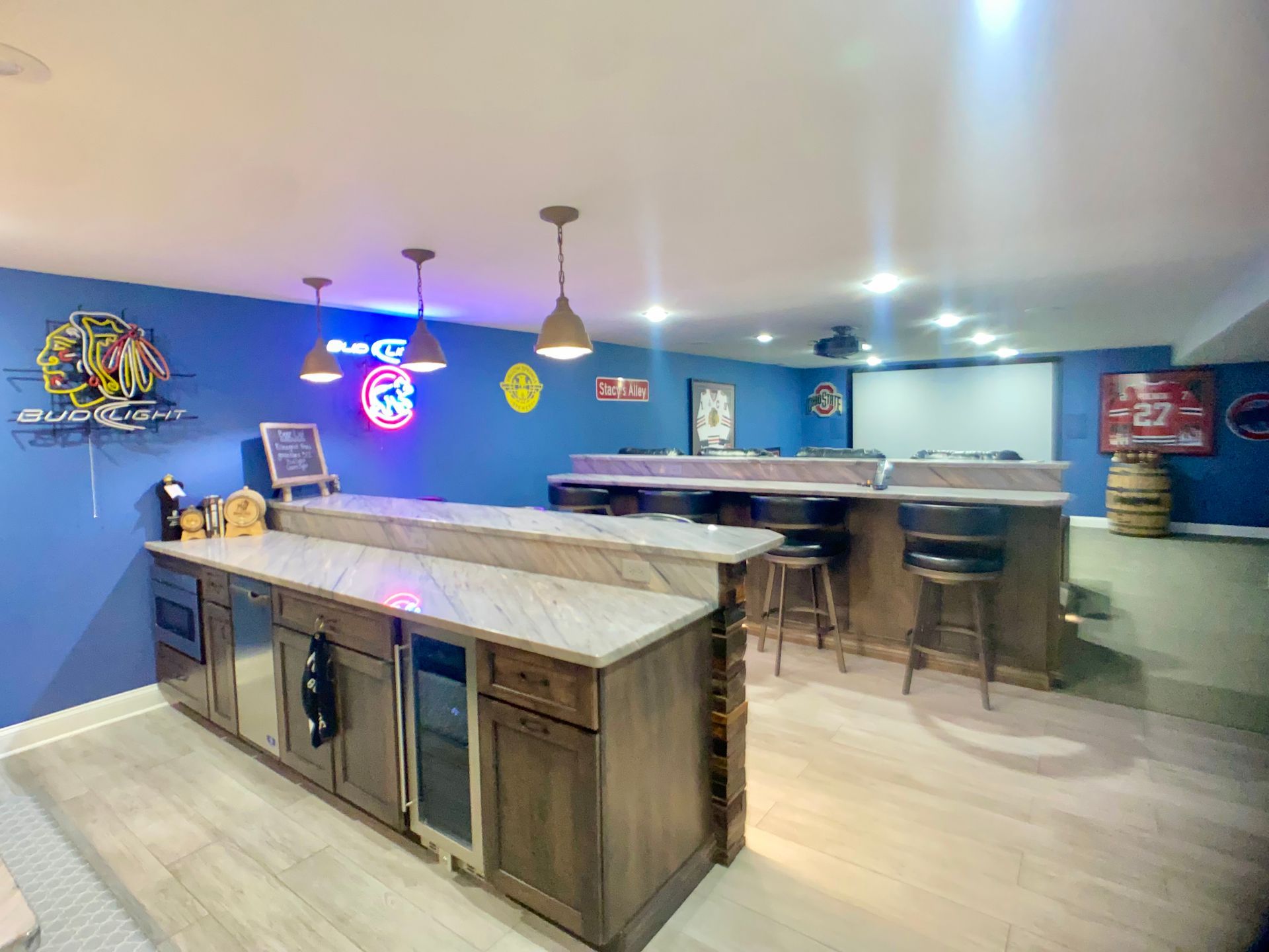 Peninsula-style custom bar with wood cabinetry in a Northern Kentucky basement — Wood and Stone Cabinet Design Studio.