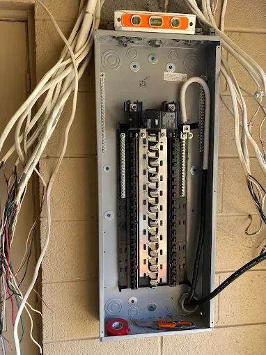 Electrical panel, open, with wires. Level on top.