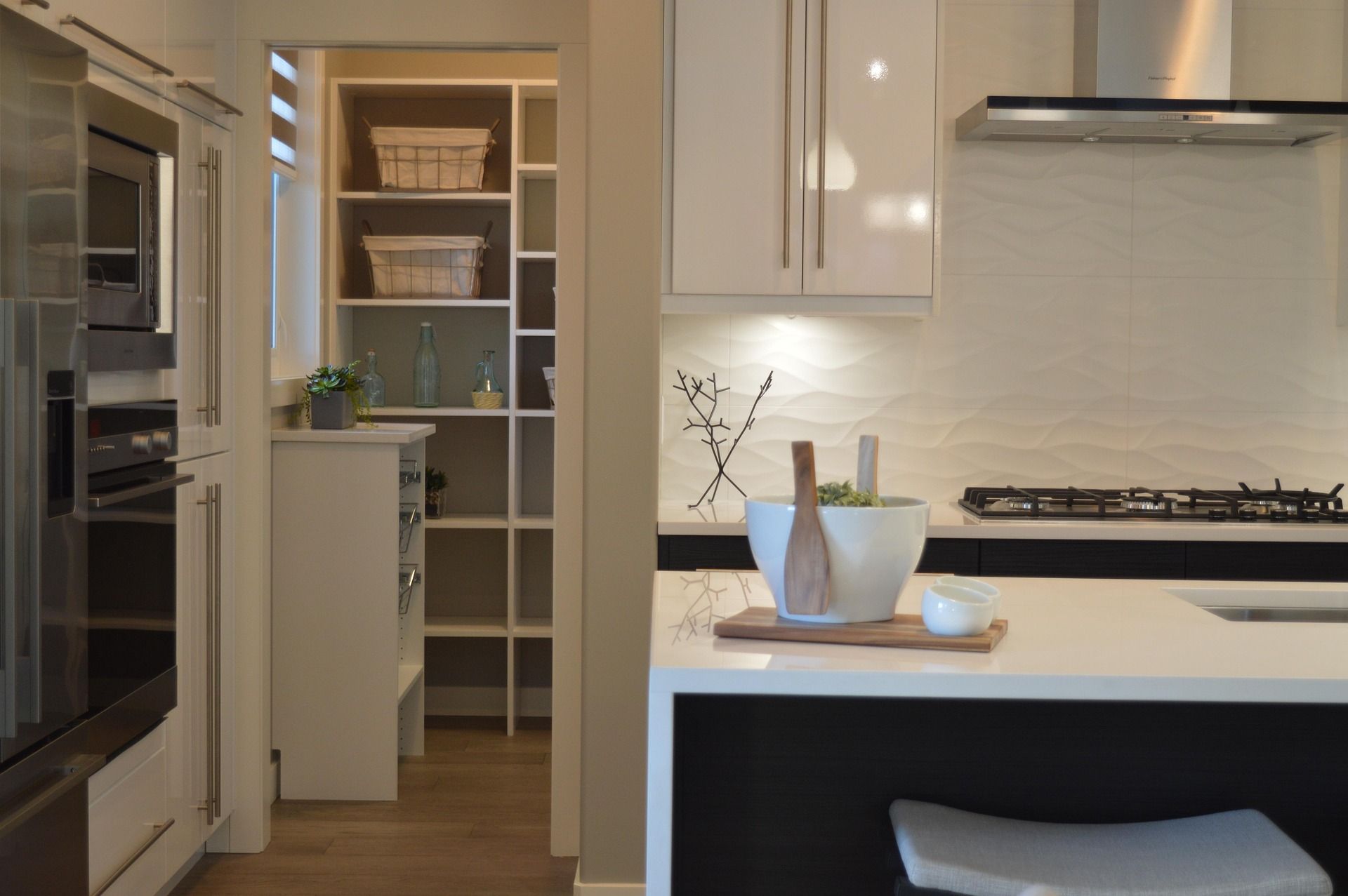 Modern kitchen with white cabinets, pantry storage, and clean counters in North Peoria, AZ