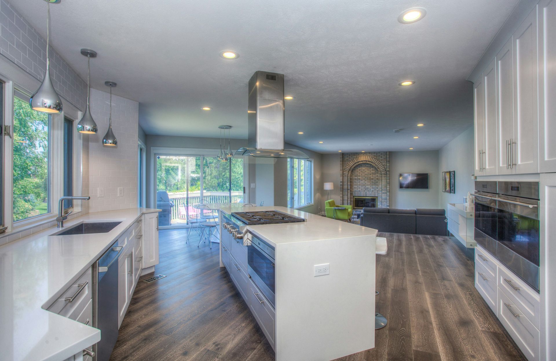 Open kitchen with white island, wood flooring, and stainless hood in Vistancia, AZ